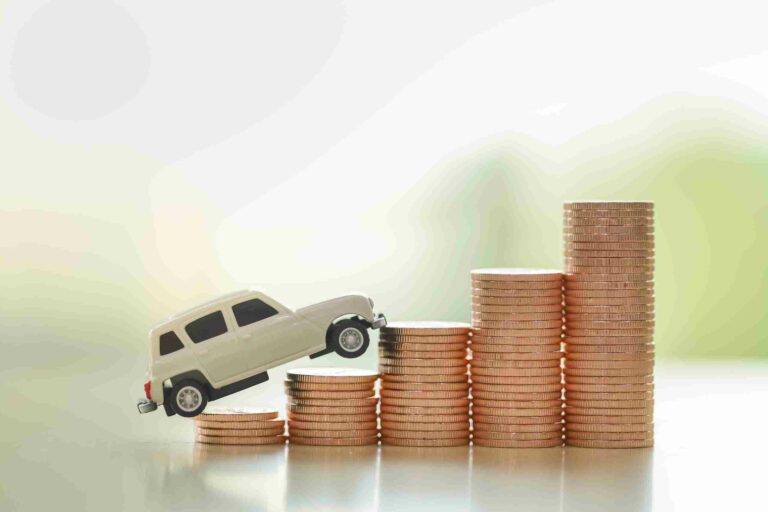 petite voiture miniature sur une pile de pièces