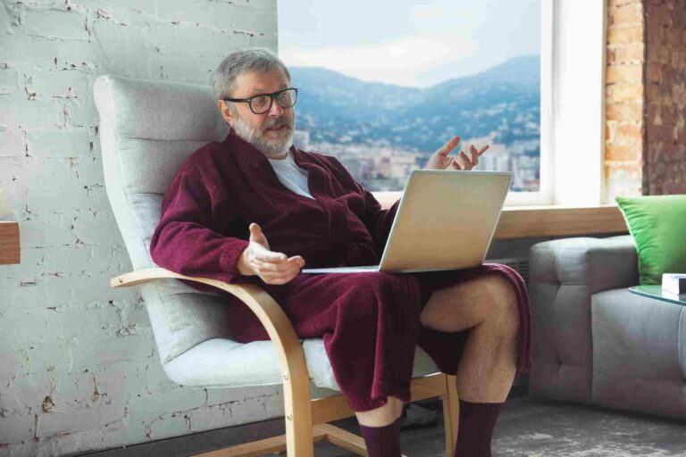 Acheter ma voiture en ligne et en visio vieille homme assis avec son ordinateur sur les genoux